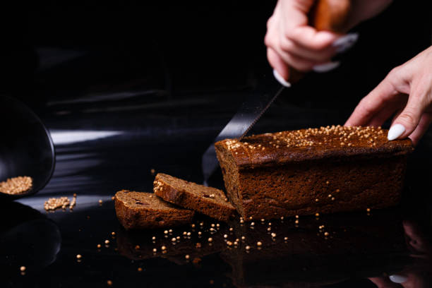 istock Homemade black bread on a black background. Photo in section. 1268778693