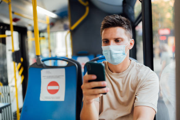 istock Young Caucasian man sitting on a bus, using a smart phone 1268779339