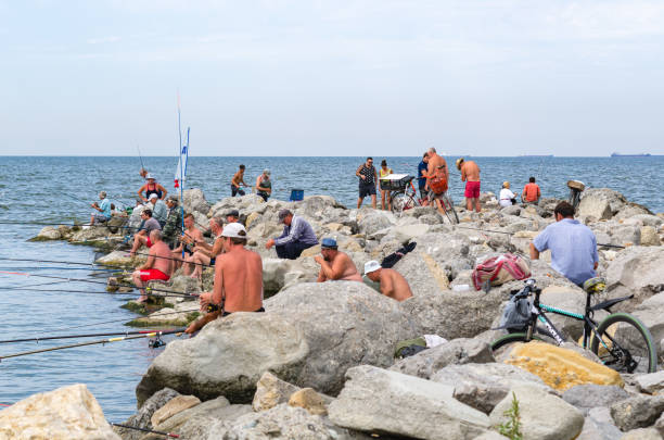 Yeisk, Krasnodar region, Russia - August 14, 2016: People fish on the stone seashore