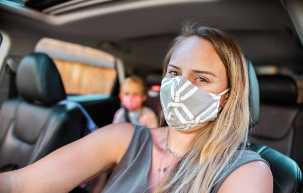 istock Mother and Daughter with masks inside the car 1268794070