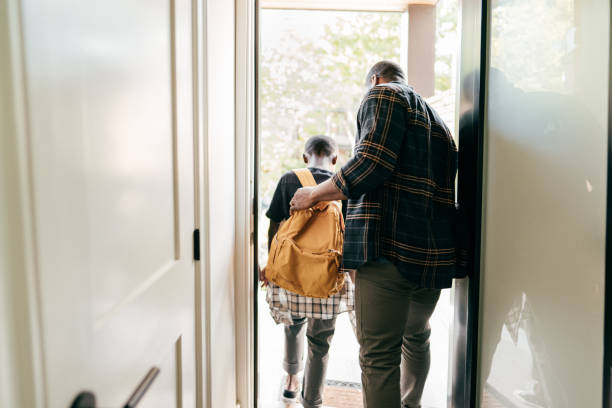istock Dad helping his son to leave the house with backpack 1268794072