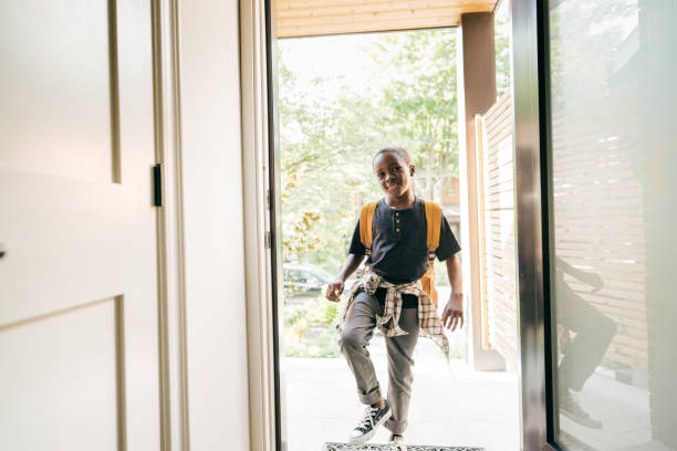 istock Elementary age student returning home with backpack from school. Entrance frame and smiling boy 1268794074
