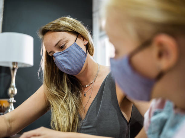 istock Mother and Daughter getting face masks on 1268805036