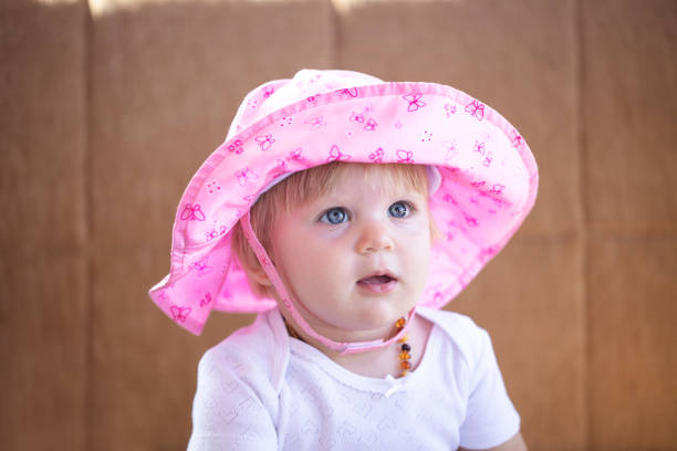 Baby girl in cute pink hat.  Selective focus on eye.