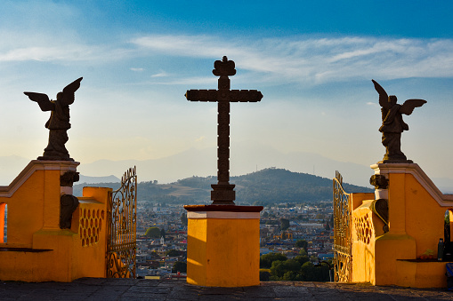 View of the City from the heights of the Sanctuary of the Virgen de los Remedios: The church on the hill is built on the Tlachihualtepec -better known as the great pyramid-, this monument was built in 1594 as a simple hermitage, but in 1864 it was destroyed by an earthquake so it was rebuilt. The interior is decorated with inspiration from the Baroque style, with magnificent wooden altars and golden ornamentation in vaults and walls.