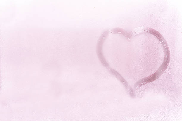 istock wet glass texture. heart drawn by a finger on a stele. light romantic background 1268832235