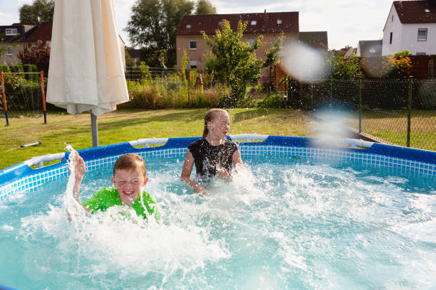 istock Boy and girl playing in pool 1268834921