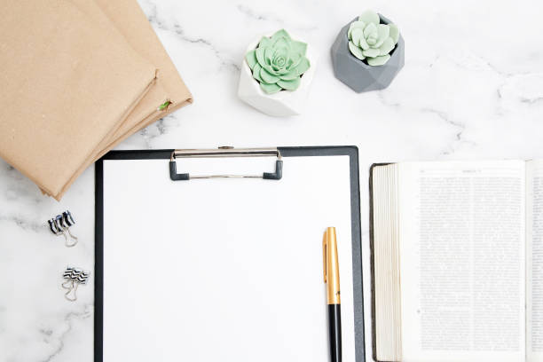 istock Desktop with a bible and mock-up clip board for notes. Bible study concept 1268837117