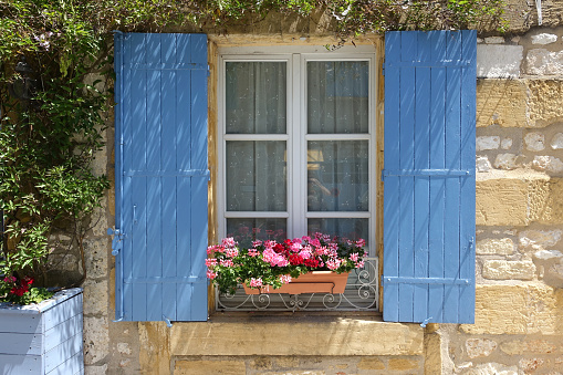 Window with blue shutters and window box of flowers