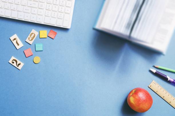 istock Back to school concept flat lay photography. Table top view. Computer keyboard, open book, pen, pencil, wooden ruler and red apple 1268852793