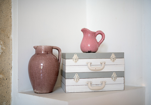 Interior decor with two pink pitchers and two vintage style cases