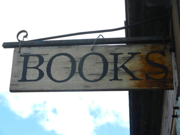 istock Old Bookstore Sign hanging from wall with blue cloudy sky at the back 1268861010
