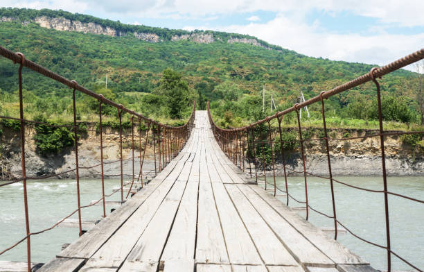 istock old wooden bridge across mountain river in Adygea. 1268868276