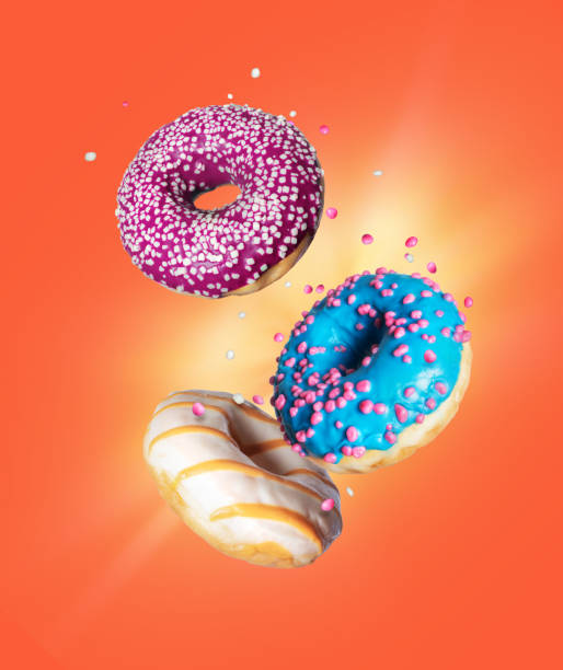istock Various donuts with motley glaze in the air on a red background 1268882306