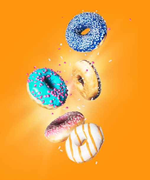 istock Various donuts with motley glaze in the air on a yellow background 1268882308