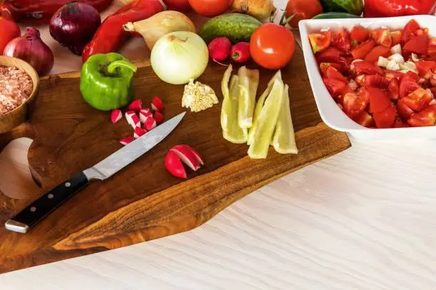Fresh vegetables cucumber tomatoes pepper on kitchen cutting board. Homemade preparation of vegetable salad. Healthy food.