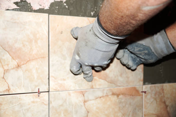 istock a man laying ceramic tiles on the wall close-up 1268888370