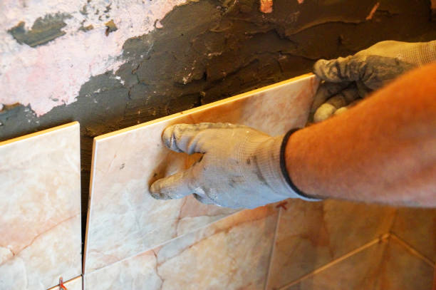 istock a man laying ceramic tiles on the wall close-up 1268888375