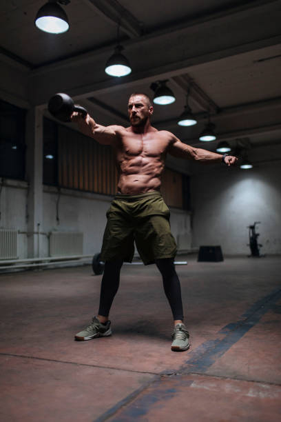 working with the kettlebell - shirtless energy action effort imagens e fotografias de stock