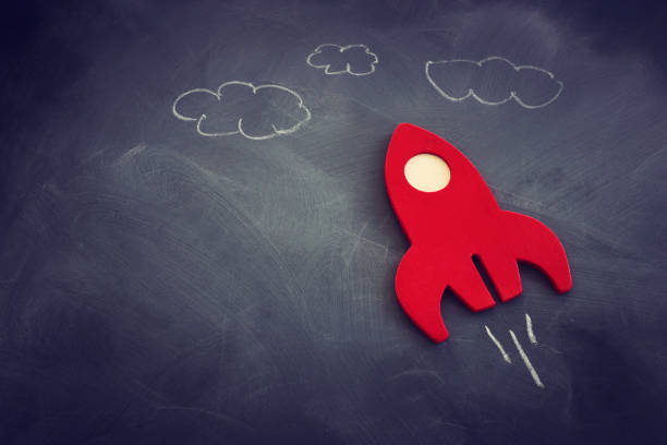 istock education or innovation concept. Wooden rocket over blackboard background. top view 1268908282