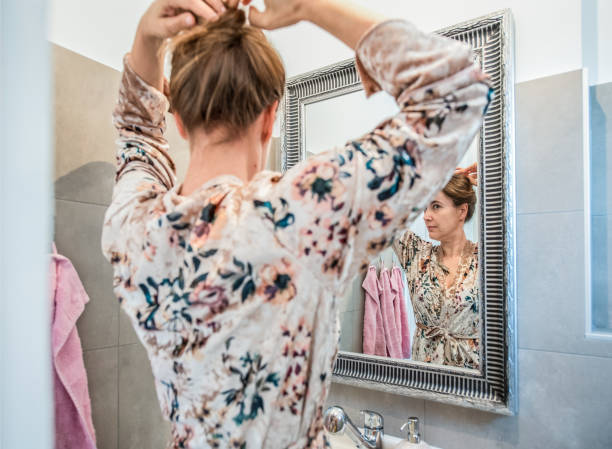 beautiful woman in the morning bathroom routine - woman in mirror backview imagens e fotografias de stock