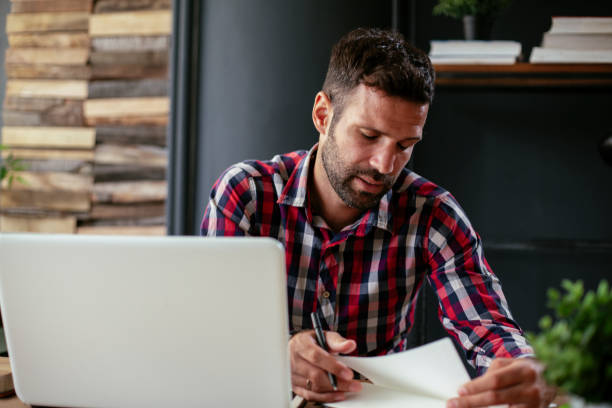 istock Businessman sitting at office desk working on laptop computer 1268911721