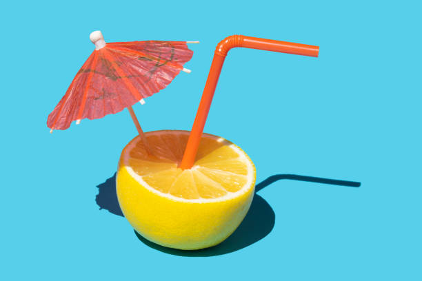 fruit de citron avec la paille et le parapluie de cocktail - drink umbrella umbrella drink isolated photos et images de collection