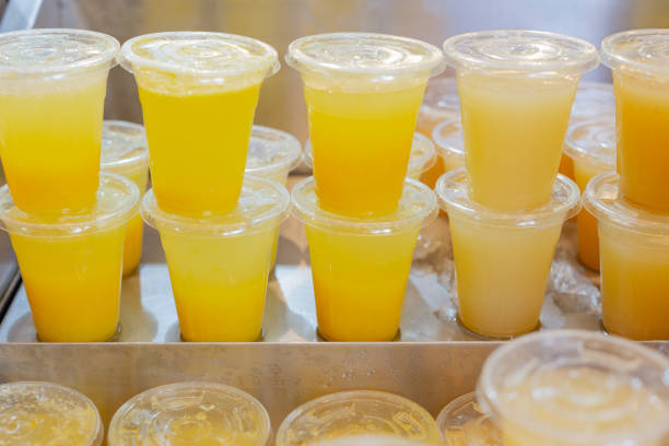 istock Delicious lemonade smoothies in plastic cups with different flavors: pineapple, apple, cranberry, strawberry. Placed on top of each other in rows. Sold in shop, at street fair for healthy lifestyle 1268919913