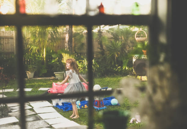 Child outdoors playing seen through a window Abstract ethereal image of child playing outside seen through a window in the foreground peeking photos stock pictures, royalty-free photos & images