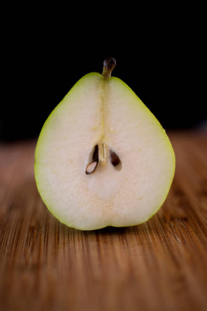 Pear on wooden table and black background