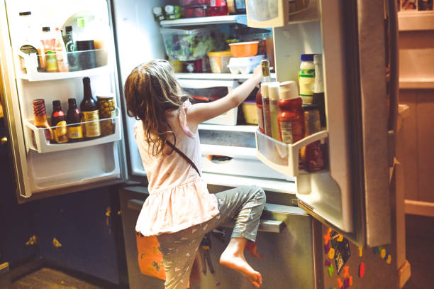 istock Child climbs into the family refrigerator 1268928960