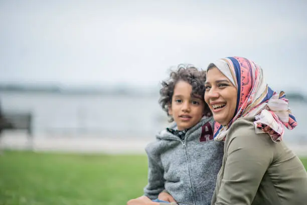 Muslim mother and her son embrace and enjoy time in the city together.