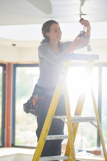 istock female electrician installing downlights 1268936954