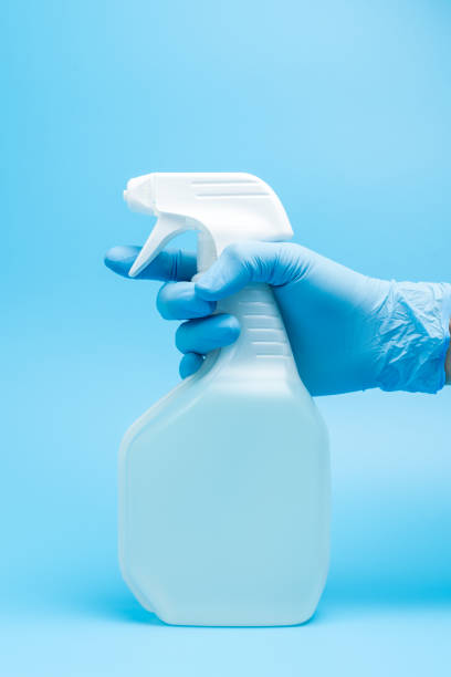 istock Hand in glove holds disinfectant spray 1268950736