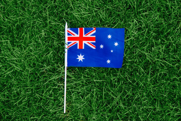 australian flag lying on green grass. australia day national holiday celebration. nature background outdoors. - australia australia day celebration flag imagens e fotografias de stock