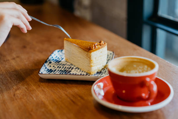 istock Woman in a cafe eating crepe cake with fork 1268954608