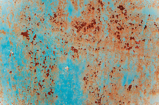 old iron wall with blue paint and rust. Metal texture with natural defects. Scratches, chips, cracks, dust.a background or poster for an inscription