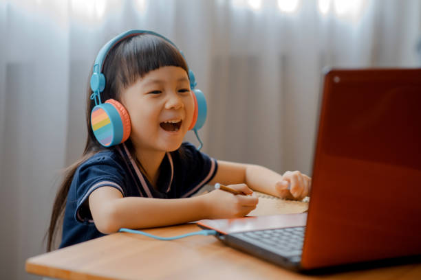 istock Little Asian girl using laptop to studying 1268967500