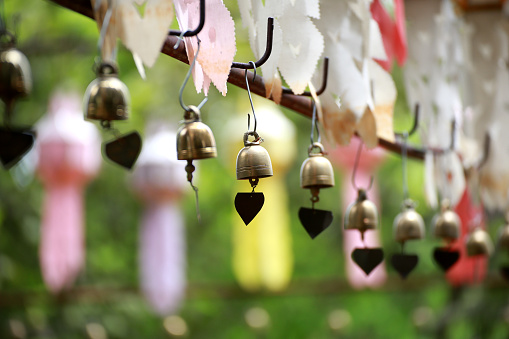 Golden small bell hanging on steel bar in Thai temple or holy place, Asian temple decorative style