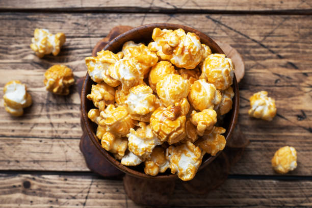 istock Popcorn in caramel glaze in wooden plates on a rustic table. Copy space. 1268967601