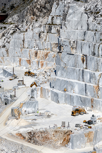 Terraced rock face in open cast Carrara marble mines or quarries in an elevated view in Tuscany Italy