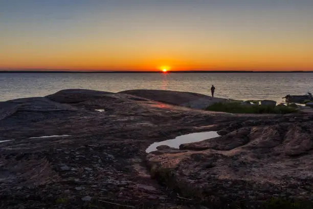 Man at sunset on the rocky shore of the Baltic Sea