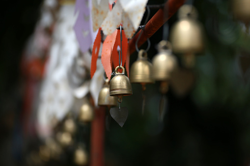 Golden small bell hanging on steel bar in Thai temple or holy place, Asian temple decorative style