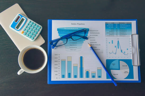 istock Office laptop business financial document chart and graph on wooden table with coffee cup. Flat lay notebook computer laptop on office desk. No people business graph chart mockup on business workspace 1268990536