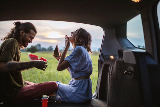 istock Couple eating watermelon in the car trunk 1268993824