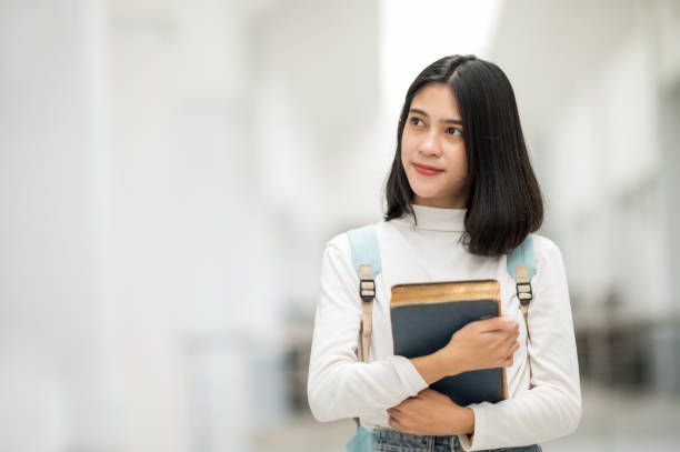 istock A female Asian college student smiled at the university and stared at the camera. 1268994870