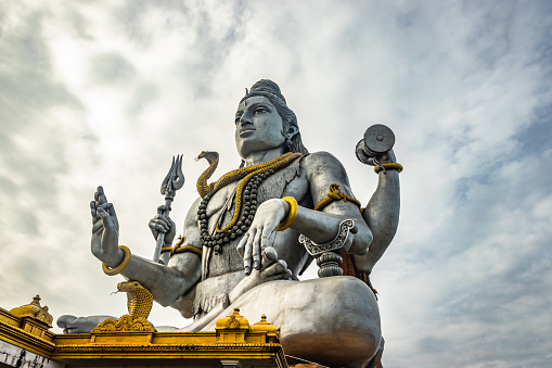 shiva statue isolated at murdeshwar temple close up shots from unique low angle image is take at murdeshwar karnataka india at early morning. it is one of the tallest shiva statue in the world.