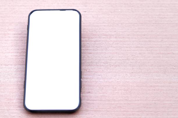 istock Black smartphone with white screen on wooden texture background 1268995914
