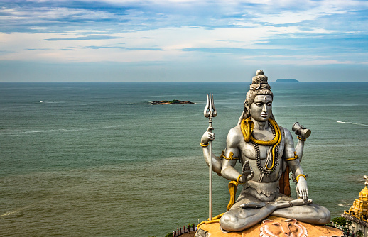 shiva statue isolated at murdeshwar temple aerial shots with arabian sea in the backdrop image is take at murdeshwar karnataka india. it is one of the tallest shiva statue in the world.