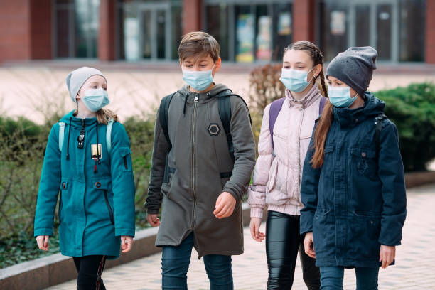 istock Children students in medical masks leave the school. 1268997724